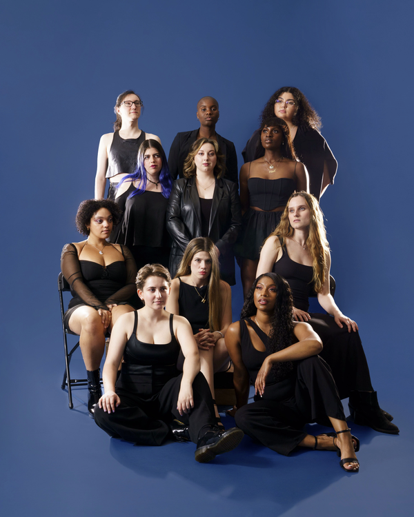 Promotional picture of our female acapella singers for events wearing all black while posing to camera in front of all blue background | Altus Entertainment